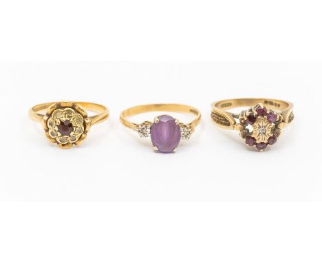 Three gem set 9ct gold rings to include a ruby and diamond cluster, size O, an amethyst and diamond three stone ring, size M 