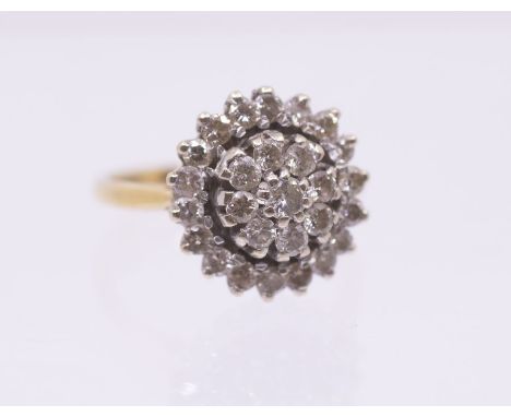A diamond and 18ct gold cluster ring, the centre set with a flower cluster of round brilliant cut diamonds, to an outer tiere