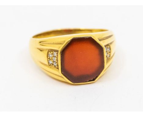 A gents carnelian and diamond set ring, comprising a hexagonal flat cut carnelian, ridged shoulders set with five small diamo