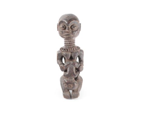 A Kuba maternity seated figure, Democratic Republic of Congo, the forehead and cheek with deep scarification marks, with pron