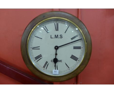 A beech circular wall clock, the dial bearing inscription, L.M.S. Crewe