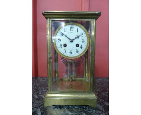A 19th Century French brass and glass four sided clock, the enamelled dial signed by retailer Harrods, London S.W.