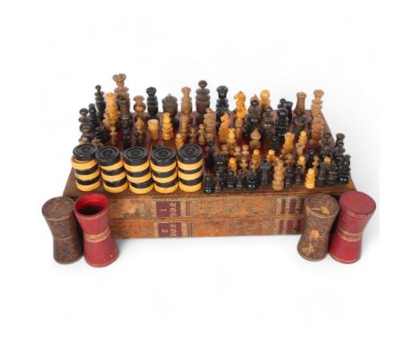 A selection of Antique and other turned wood chess pieces, and a selection of Vintage draught pieces, housed within a faux le