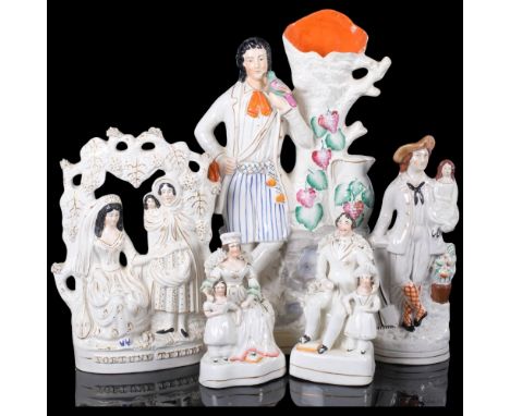 A group of Staffordshire ceramic figurines, including a flatback fortune teller, a large flatback spill vase with gentleman h