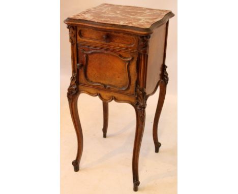 A French marble topped carved walnut bedside stand, circa 1900
The serpentine top above panelled single drawer and cupboard d