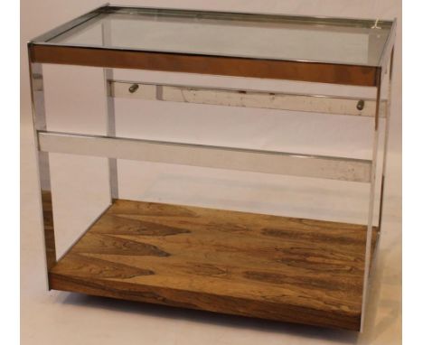 Post war chrome and rosewood tea trolley
Of rectangular form, having chrome mounts and panels, supporting a central glass top