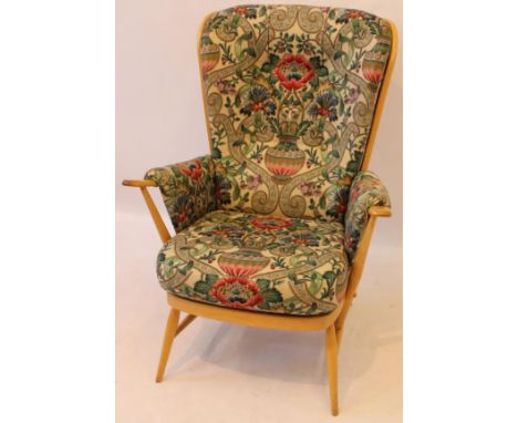 A Contemporary Ercol light elm spindleback armchair
Upholstered with a floral decorated seat cover and cushion, raised on col