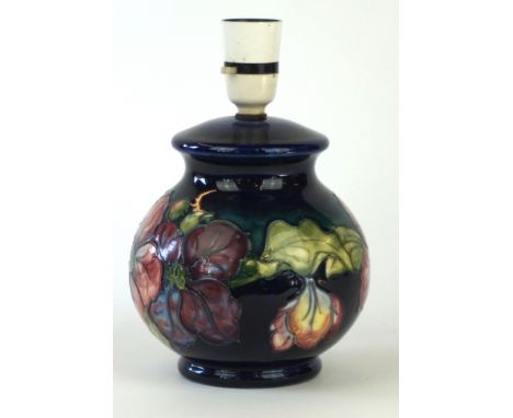 A Walter Moorcroft bulbous form lamp base
Decorated in the Clematis pattern on a blue and green ground, impressed factory mar
