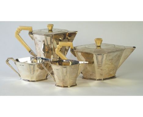 An Art Deco hallmarked silver four piece tea service
Comprising teapot, hot water jug, each with ivorine finials and angular 