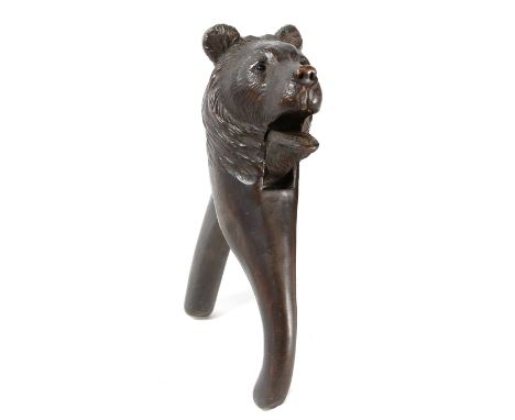 An early 20th Century carved Black Forest type nutcracker
In the form of a black bears head extending to lever handles, appli