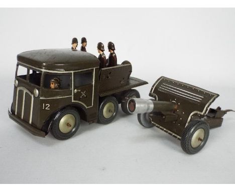 Joustra - A vintage clockwork tinplate Army personnel carrier with five soldiers on board towing a field gun trailer. The tru