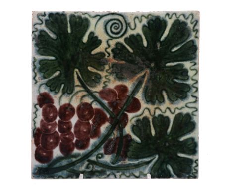 A William de Morgan 6in tile, painted with vine leaves and a bunch of grapes  A William de Morgan 6in tile,   painted with vi