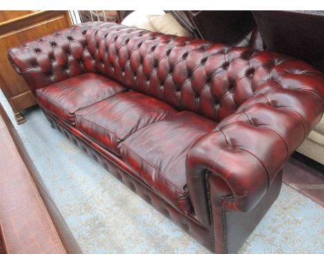 CHESTERFIELD SOFA BED, three seater, with a buttoned back, inner sides and red leather upholstery, 206cm L x 76cm H x 90cm D.