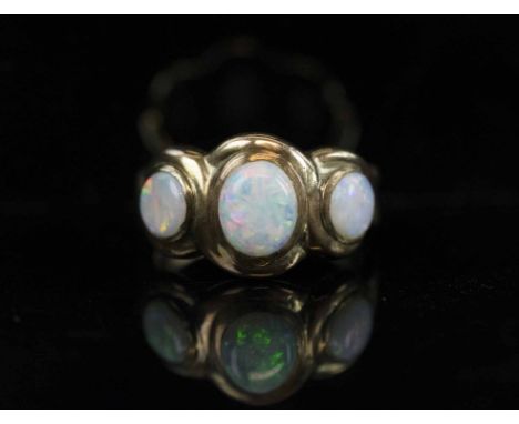 ANTIQUE OPAL AND GOLD THREE STONE RING, the opals slightly graduated with good display of colour mounted in 10K yellow gold.