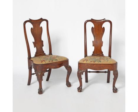 Mid-18th centuryThe foliate carved dipped top rail above a paper-scroll carved vasiform splat above a drop-in needlework upho