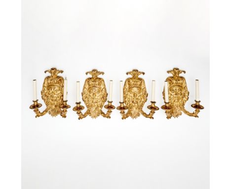 Each backplate cast with a bearded male mask surmounted by an acanthus form crown and applied with two candle arms.Height 24 