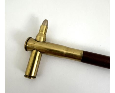 A novelty walking stick, the handle and finial in the form of bullets, one passing through the other, 94 cm 