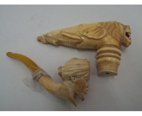 Early 20th century carved ivory walking cane topper carved as a lion with elephants trunk together with a meerschaum pipe 