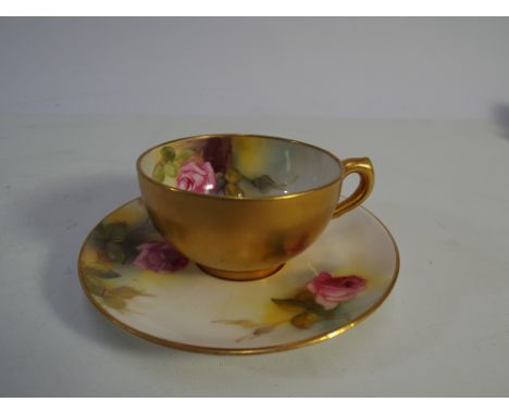 A Royal Worcester cabinet cup and saucer decorated with roses signed M Hunt 