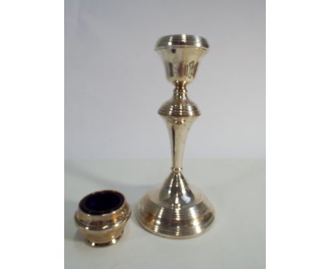 A modern silver candlestick on weighted base and a silver salt cellar with blue glass liner 