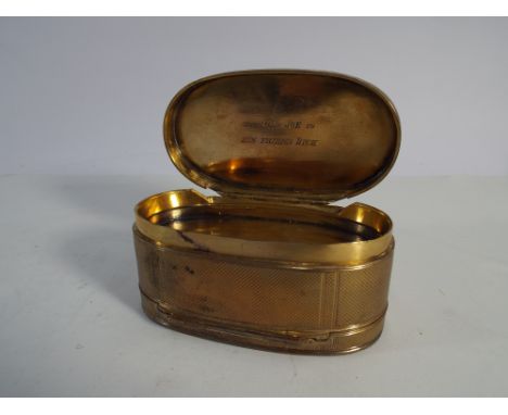 An oval gilt metal double sided table snuff box with engine turned decoration 10cms across