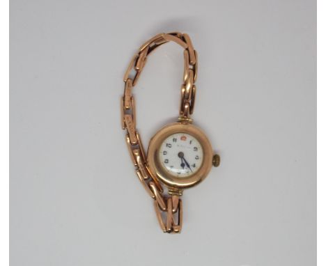 Vintage 9ct rose gold ladies wristwatch with white enamel dial and Arabic numerals on a flexible plated strap