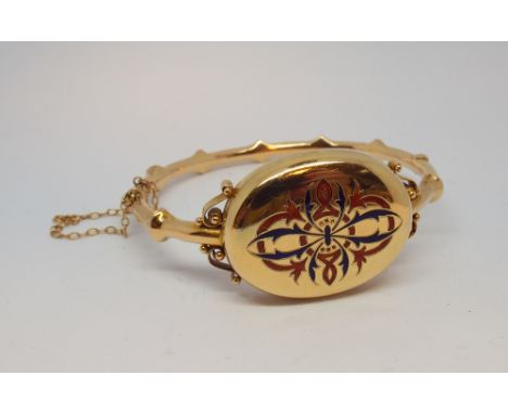 Victorian gold and enamel locket style bangle, with oval locket compartment to the centre inset with red and blue enamel, hin