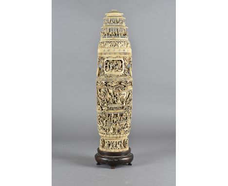 An early 19th Century Chinese ivory twin handled vase and cover, with all over carved decoration of figures, in a hierarchica