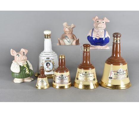 A set of four graduated Wade blended scotch whisky Bells decanters, with contents together with a commemorative Wade decanter