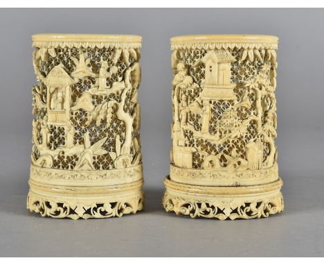 A pair of 19th Century Chinese ivory carved and pierced sleeve vases, with prunus trees and figures within a landscape, 8.5 c