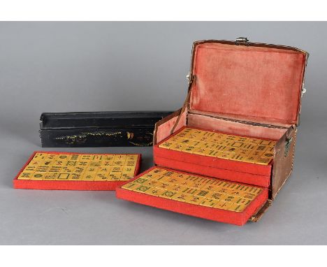 An early 20th Century resin mah jong set, with bone counters and lacquered counter stands in a leather caseSeveral tiles are 