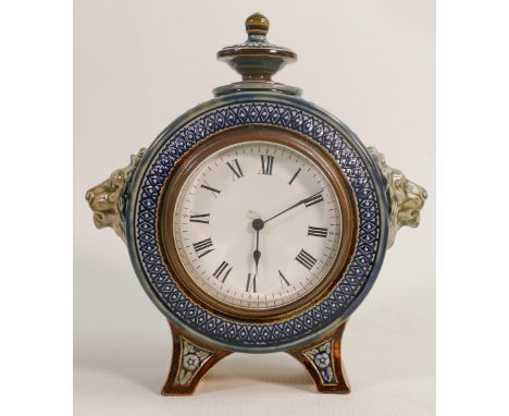 Doulton Lambeth stoneware clock case, with lions head handles on splayed bracket feet, h22cm. Later battery clock movement fi