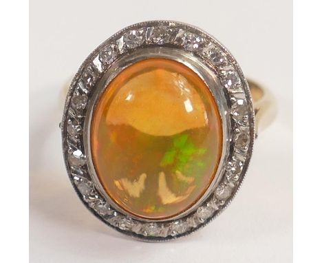 Yellow metal precious mexican fire opal ring set with diamonds, tested for 14ct gold, oval opal approx 6ct, 5.4g. 