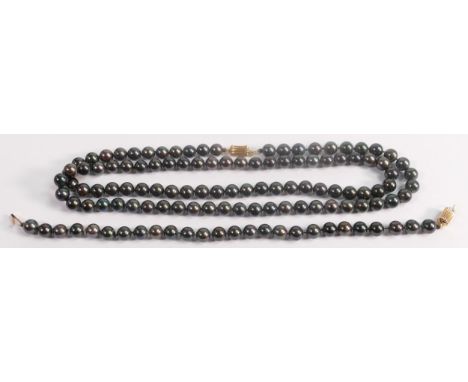String of black cultured pearls, together with matching bracelet, catches are both stamped 14ct gold.  Necklace measures 67cm