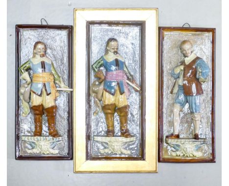 Three high relief continental Majolica wall plaques with figures in period dress, each 38 x 16cm, one item with major repair 