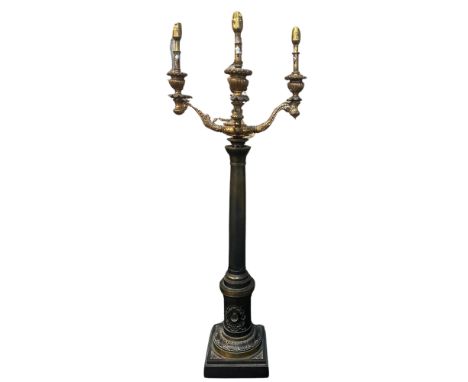 A 19th century bronze and gilt metal five branch candelabra, raised on a central tapering cylindrical column, the lower drum 