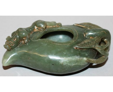 A GREEN JADE-LIKE VESSEL carved with a tiger and leaves. 4.5ins long. 