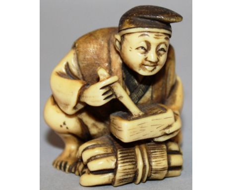 A JAPANESE NETSUKE, a seated man stirring a box. Signed 1.75ins. 