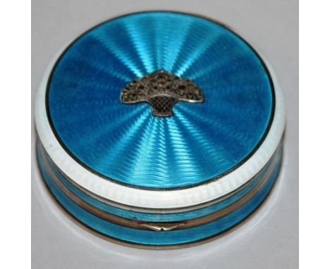 AN EDWARDIAN SILVER AND BLUE ENAMEL CIRCULAR COMPACT, the top inset with marcasite flowers and with mirror inside Stamped .92