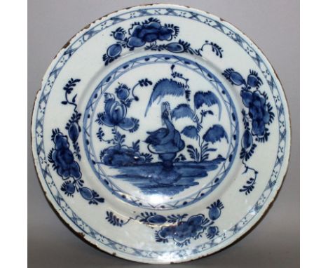 A DELFTWARE CIRCULAR CHARGER, CIRCA 1760, painted with under-glaze blue, central bird fountain, flowers and floral border 13.