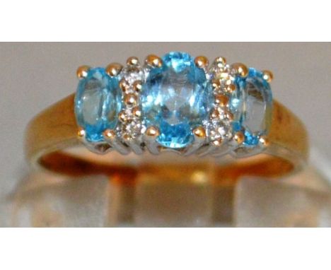 A LOVELY THREE STONE LIGHT BLUE AND DIAMOND RING set in 9ct gold. 