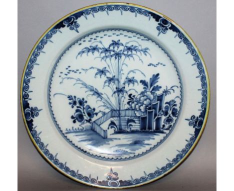 A DELFTWARE CIRCULAR CHARGER, LONDON, CIRCA 1780, painted with under-glaze blue with garden and fences and rectangular rocks,