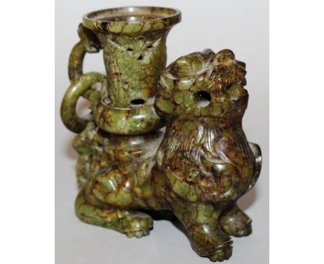 A CHINESE SPECKLED JADE DOG OF FOE CANDLESTICK with carved pierced ring. 3.5ins high. 