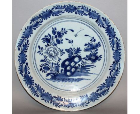 A DELFTWARE CIRCULAR CHARGER, CIRCA 1760, painted with under-glaze blue, fence and flowers with continuous fluted border. 12i