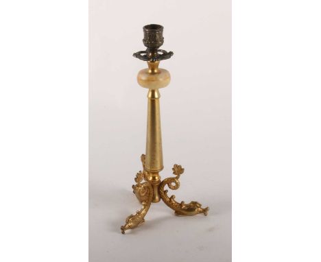 A brass candlestick, with a turned brass support above cast dolphin feeth. 30cm