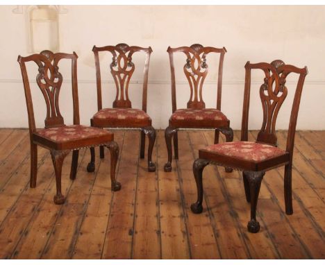 A set of four mahogany Chippendale style dining chairs, each with red floral embroidered fabric drop-in pad seats and raised 