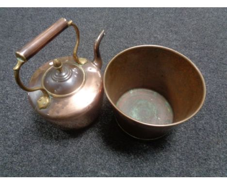 An antique copper and brass kettle together with a copper and brass planter 
