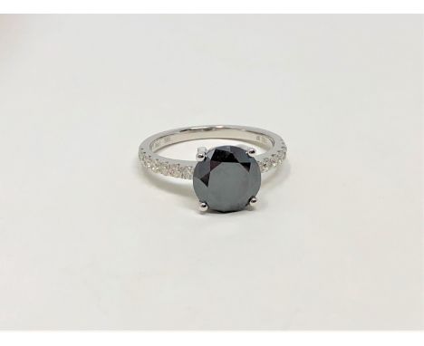 A 14ct white gold diamond ring, featuring centre round brilliant cut black diamond (1.59ct), claw set with fourteen round bri