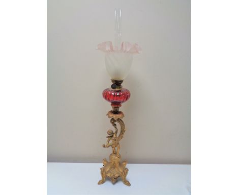 An ornate nineteenth century oil lamp modelled as a cherub with glass shade 