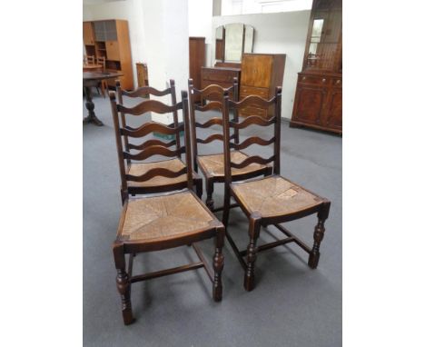 A set of four early twentieth century ladder backed rush seated kitchen chairs 
